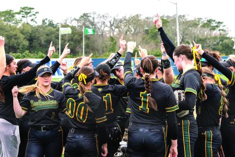 Southeastern softball ladies huddle up during a glorious Mardi Gras Mambo performance (Photo courtesy of Arief Harlan )