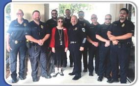 Pictured at left is Head of School Mrs. Sue Courtney (in red) with representatives of HPD (left to right): Juvenile Detective Samantha Stevens, School Security Officer Wade Phares, Detective Corey Morse, Lieutenant Thomas Mushinskey, Chief Edwin Bergeron, Sergeant Ronnie Domiano, Detective Brandon Small, Detective Dustin Williams, and Detective Rolondo Duran.