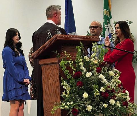 Strader Dufreche Cieutat is sworn in by Judge Jeff Johnson, who was the last person to swear in her father, former Tangipahoa Clerk of Court, Julian Dufreche, in 2016. In support at the podium were Johnny Cieutat, Strader’s husband; and their two daughters, Gabriella and Helena (not visible in photo). During the ceremony, Strader symbolically wore a strawberry pin once worn by her father.