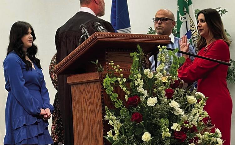 Strader Dufreche Cieutat is sworn in by Judge Jeff Johnson, who was the last person to swear in her father, former Tangipahoa Clerk of Court, Julian Dufreche, in 2016. In support at the podium were Johnny Cieutat, Strader’s husband; and their two daughters, Gabriella and Helena (not visible in photo). During the ceremony, Strader symbolically wore a strawberry pin once worn by her father.