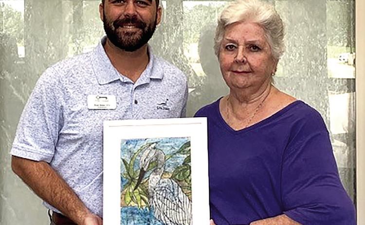 The Louisiana Growers in Amite, Rich and Susan Webb, donate a stunning painting acquired at the 63rd Annual Amite Art Show 2024 to The Lodge at Tangi Pines nursing home. Harriet Mayeaux, President of the Amite Art Club, presents the gift to Administrator Bond Babin. (Courtesy Photo)