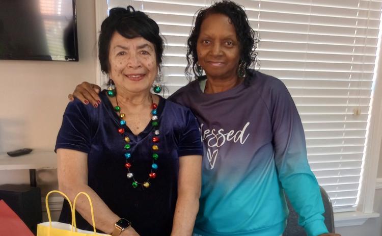 Gardenette Vicky Fannaly, left, delivers holiday ornaments to Deborah Haynes, coordinator, at Westminster Place, a senior apartment complex for their Christmas dinner event.